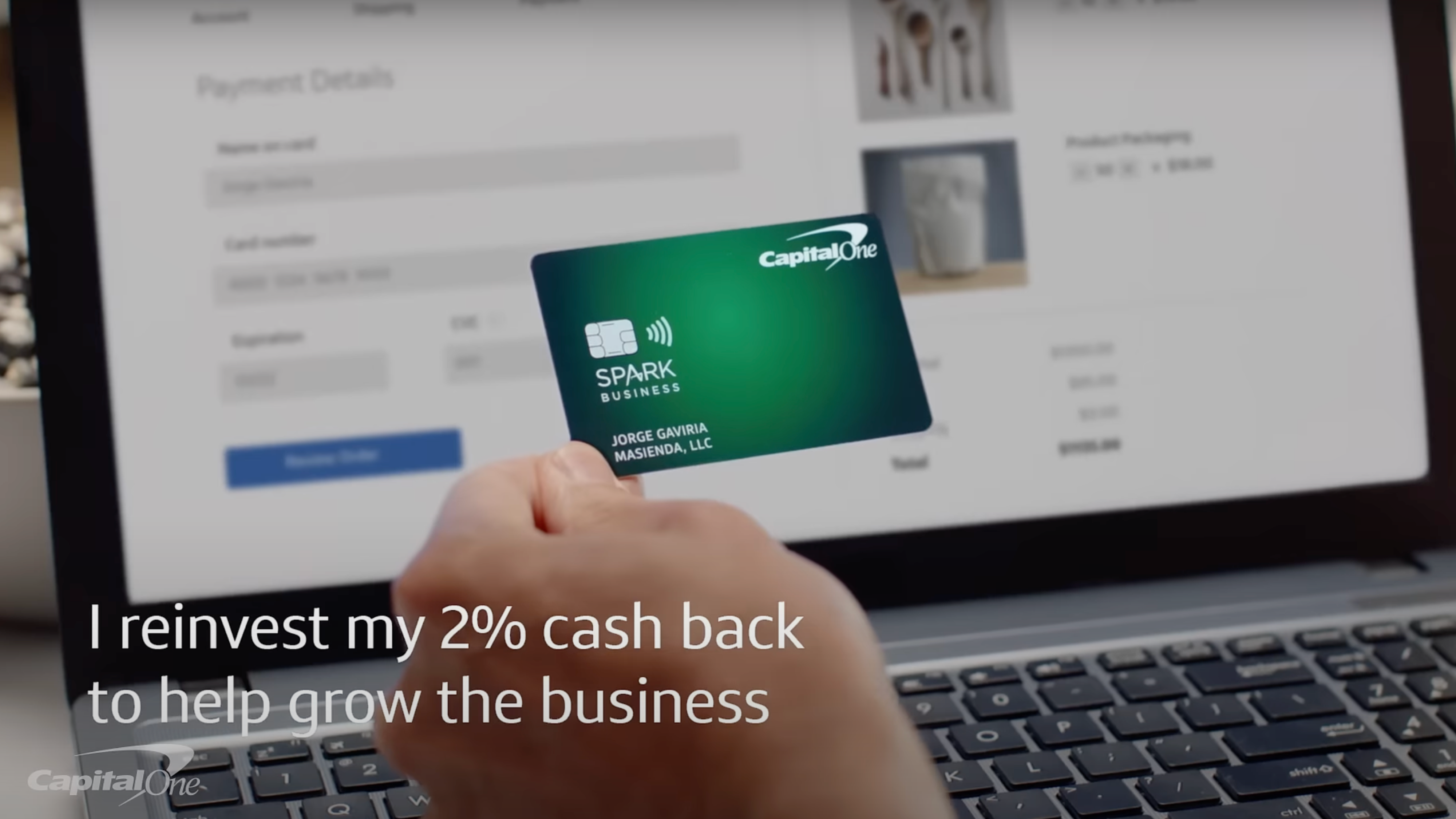 Credit card held in front of a computer screen